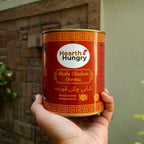 Holding a meal tin of Shahi Chicken Qorma against a wooden brick wall